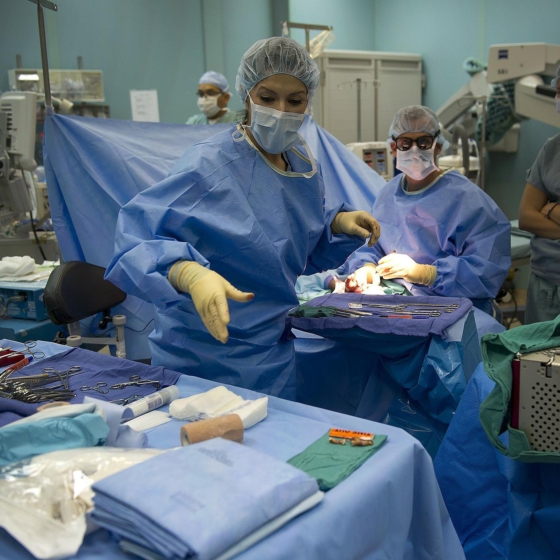 pracowniczka medyczna sięgająca po narzędzie w czasie operacji